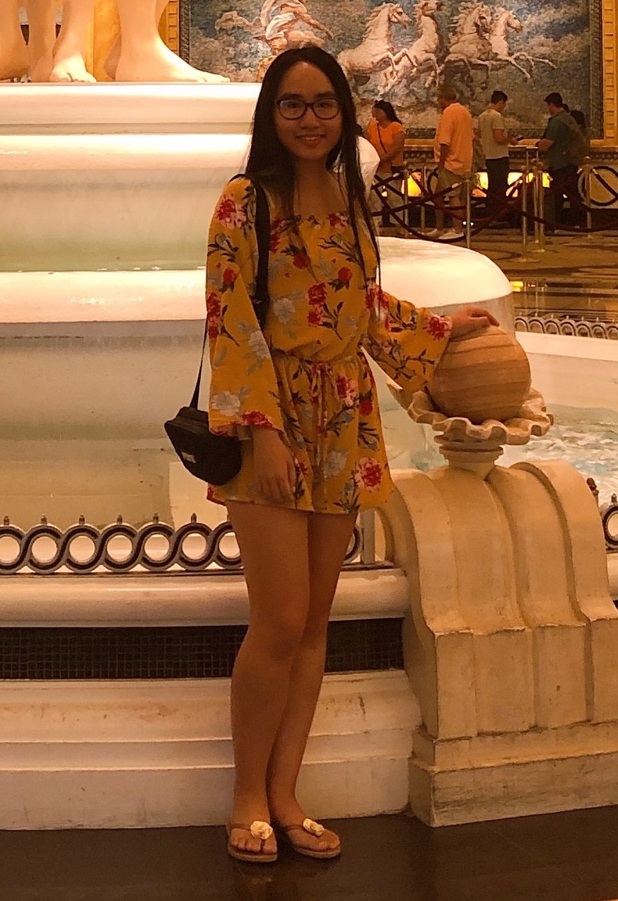Image of Nhi Duong standing next to a chair